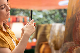 une femme prenant une photo d'une oeuvre d'art